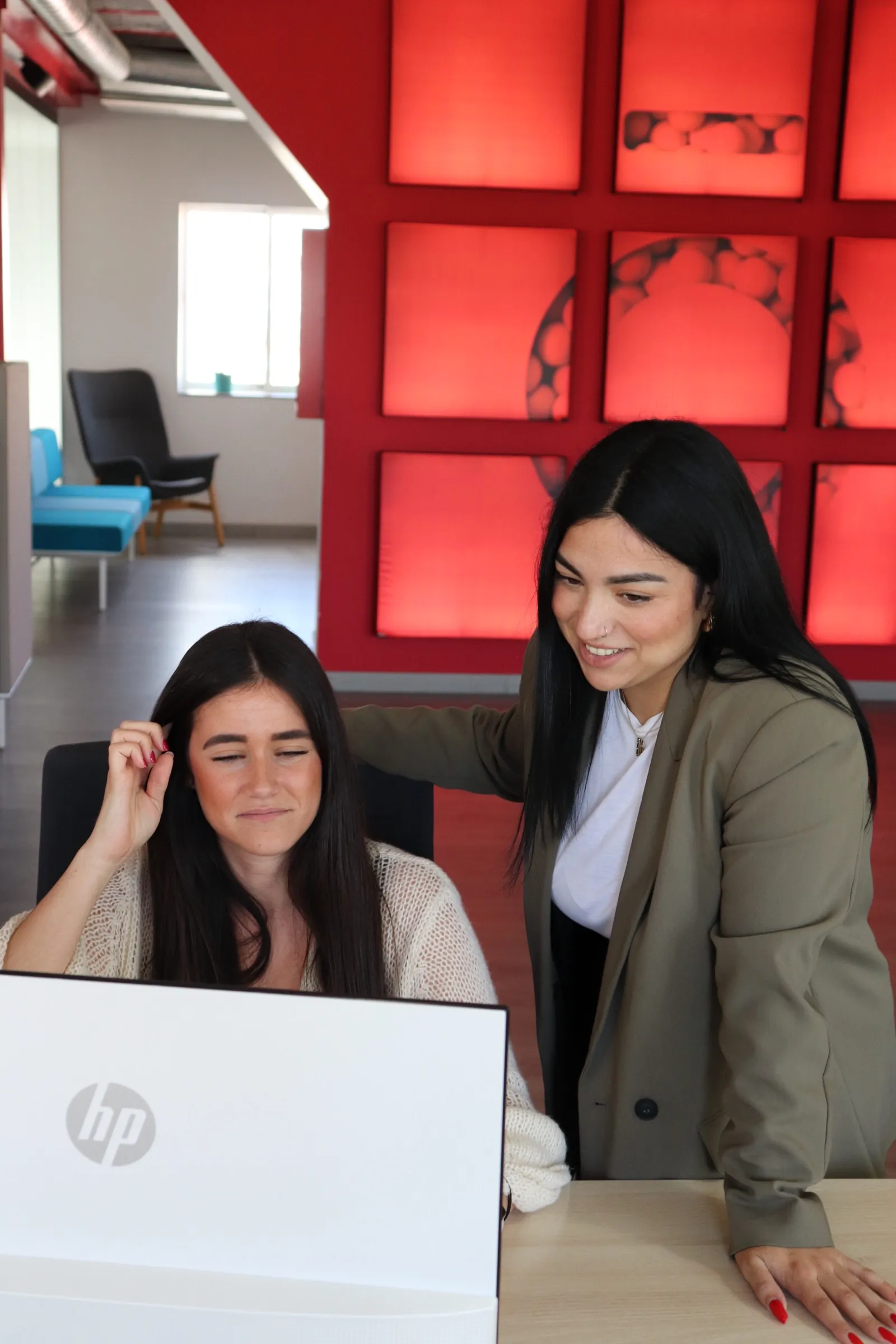 Dos personas del equipo de iberoMEDIA revisando una pantalla en la oficina